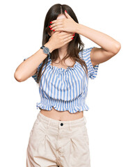 Young beautiful caucasian girl wearing casual clothes covering eyes and mouth with hands, surprised and shocked. hiding emotion