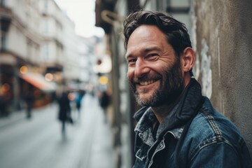Portrait of a handsome bearded man in the city. Man smiling. - obrazy, fototapety, plakaty