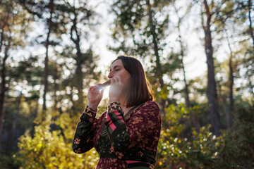 young girl plays the harmonica in the forest. the girl loves to play the harmonica.