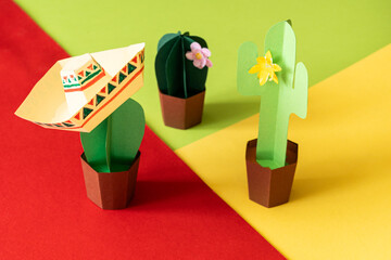 Cinco de Mayo concept - paper craft cactus in sombrero on solid color background
