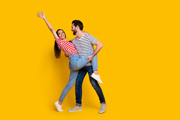 Fototapeta na wymiar Full size photo of gorgeous couple dressed striped t-shirt dancing together girl raising hand up isolated on yellow color background
