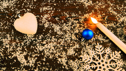 New Year's card on a wooden background.Christmas balls are toys.a burning candle.santa...