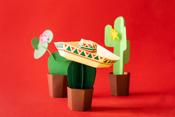 Cinco de Mayo concept - paper craft cactus in sombrero on solid color background