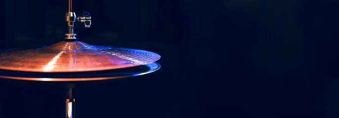 Part of a drum kit in the dark with beautiful lighting.