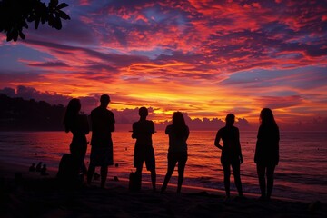 A Group of Friends Gathered in Silhouette Against a Vibrant Sunset Sky Reflecting on the Passing Day and the Beauty of Nature