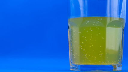 glass with vitamin c on blue background