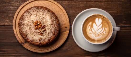 Fototapeta na wymiar Coffee in a cup and a delicious cake placed on a wooden table