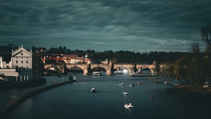 Fototapeta premium a river that is next to a bridge with boats floating in it