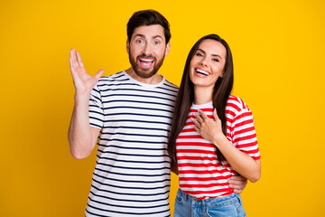 Photo portrait of lovely young couple hug excited expression impressed dressed stylish striped garment isolated on yellow color background
