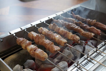 Grilling lamb skewers over charcoal