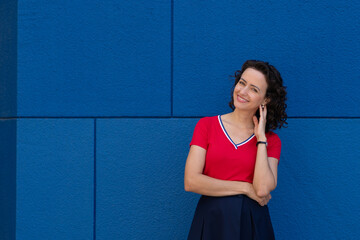 Woman in a Deep Conversation by a Blue Wall, copy space.