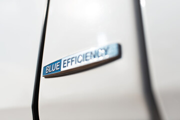 Blue efficiency icon on white car body.