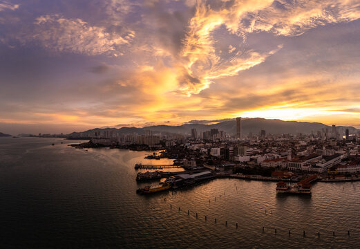 Penang, Malaysia: Dramatic aerial panoramic view of the sunset over Georgetown historic colonial city center with ferry terminal and harbor in Malaysia.