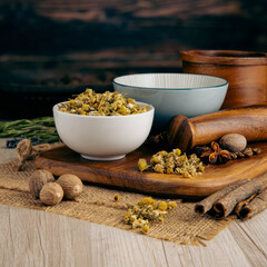 CAMOMILE FLOWERS DRIED on wooden table background. Herbs, spices and dried food baking ingredient. Mortar and different spices. Cottage kitchen. Product Photography