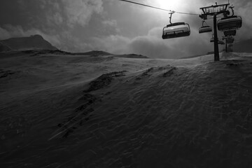Fototapeta na wymiar Ski Lift on a stormy day goiing up the mountain, black and white