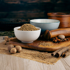 CUMIN SEEDS on wooden table background. Herbs, spices and dried food baking ingredient. Mortar and...