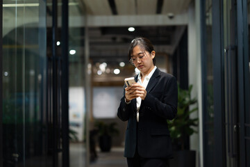 Portrait of young Asian woman with smile. happy asian businesswoman using mobile phone. Modern office workplace