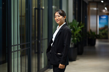 Portrait Smiling confident young business woman standing at home office. looking at camera arms crossed