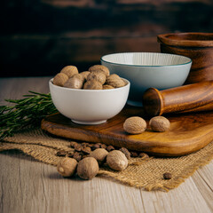 Nutmeg Whole on wooden table background. Herbs, spices and dried food baking ingredient. Mortar and different spices. Cottage kitchen. Product Photography