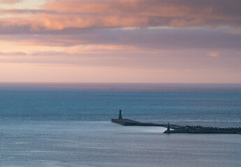 Lonely lighthouse standing on the sea of Keelung port, with beautiful sunset and colorful cloud, shoot in long lens, in Keelung, Taiwan.