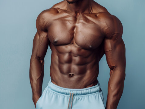 Torso di modello fitness afroamericano in pantaloncini blu chiaro con muscoli addominali ben definiti, sfondo tono su tono turchese , sport