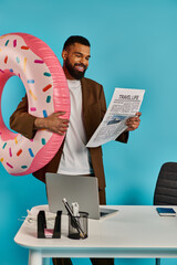 A man playfully holds a giant donut in front of his face, giving the illusion of wearing it like a...