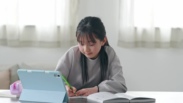 タブレットPCを見ながら勉強する女の子