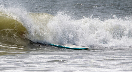 A surfboard in a wave after the surfer fell off