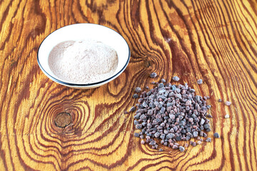 Black Kala namak salt in a salt shaker and on a wooden table