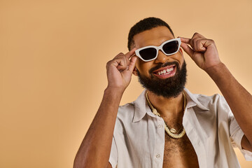 A man with a stylish beard and trendy sunglasses exudes confidence and charisma as he poses for the...
