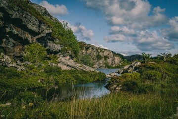 Scenic view of a lake under rocky hills in the forest on a sunny day