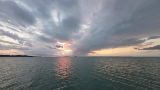 Time-lapse drone footage over the surface of a sea under the cloudy sky