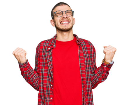 Hispanic young man wearing casual clothes very happy and excited doing winner gesture with arms raised, smiling and screaming for success. celebration concept.