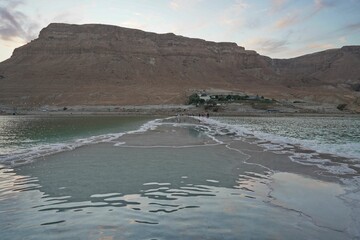 Beautiful shot of the Dead Sea coast in Israel with salt crystal formations under a calm sky