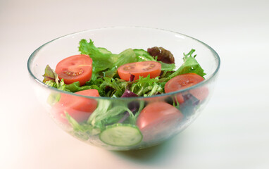 fresh vegetable salad in a transparent plate frillis cucumber tomato