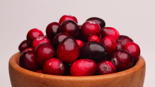 fresh red cranberries, rotation in circle. lingonberry red berries in a wooden bowl on a white background, Turning. selective focus.  	
