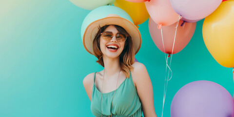 Happy smiling woman with an air colorful balloons over a on teal color background professional photography