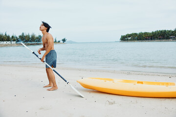 Happy Asian Man Kayaking in Leisure, Enjoying Summer Vacation on Tropical Beach