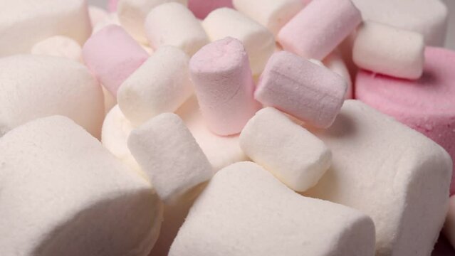 white and pink marshmallow, rotation in circle. marshmallow for cocoa or for grilling, Turning. selective focus. view from above.	