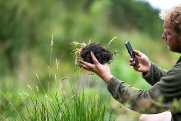 agronomiston a farm practicing agronomy holding soil, doing soil tests in her home laboratory....