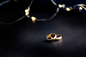 two wedding  rings on a black  with space 