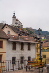 Old residential buildings in the mountain village of Rigolato in Carnia, Friuli-Venezia Giulia,  North East Italy. The Parish Church of Saints Philip and James is in the background
