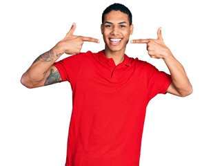 Young hispanic man wearing casual red t shirt smiling cheerful showing and pointing with fingers teeth and mouth. dental health concept.