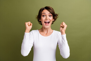Portrait of funny overjoyed lady holding raised fists open mouth big win lottery money isolated...