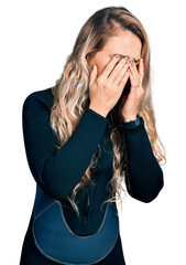 Young blonde woman wearing diver neoprene uniform rubbing eyes for fatigue and headache, sleepy and...