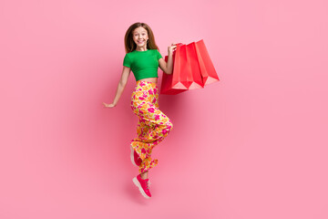 Full length photo of crazy cheerful cute youngster girl fly air hold packages low price special...