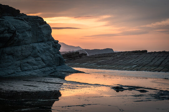 Sunset time at the coastline of Badouzi, sunlight shines on the water with gorgeous rocks by the side, in Keelung city, Taiwan.