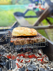 Outdoor barbecue. Meat and pita bread on a grill over hot coals