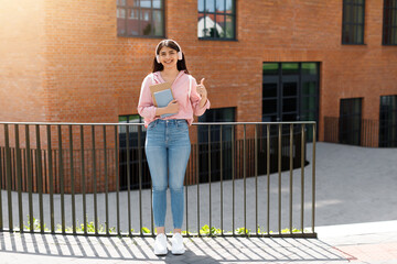 Thumbs-up from confident student girl on campus