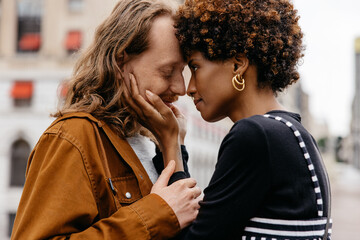 Affectionate woman embracing her partner on a city street, sharing a sweet loving moment - obrazy, fototapety, plakaty